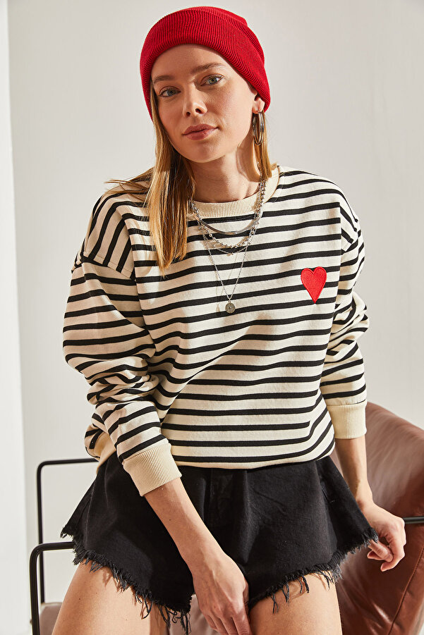 Beżowo-czarna bluza w paski to idealna baza do stworzenia wielu stylizacji. Miękka bawełna i delikatny oversize'owy krój zapewnią Ci wygodę przez cały dzień. Nadruk w kształcie serca doda Twojemu outfitowi oryginalności.