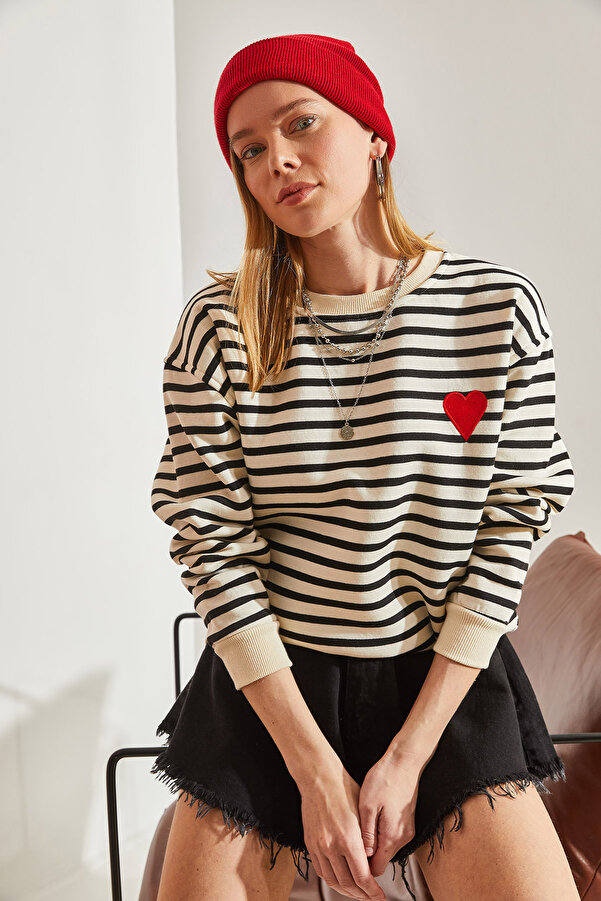 Beżowo-czarna bluza w paski to idealna baza do stworzenia wielu stylizacji. Miękka bawełna i delikatny oversize'owy krój zapewnią Ci wygodę przez cały dzień. Nadruk w kształcie serca doda Twojemu outfitowi oryginalności.