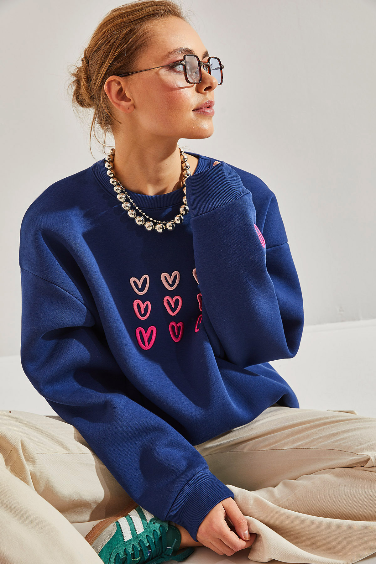  Nasza nowa bluza w kolorze granatowym to połączenie romantyzmu i wygody. Delikatne różowe, haftowane serca na miękkiej, bawełnianej tkaninie tworzą wyjątkową kompozycję. Oversizowy krój i przyjemny meszek wewnątrz zapewnią Ci ciepło i komfort