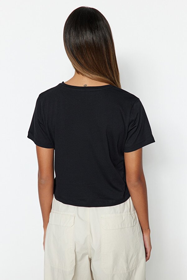 krótki top w kolorze czerni to idealne rozwiązanie. Wykonany z miękkiej bawełny, doskonale sprawdzi się podczas treningów, spacerów czy spotkań z przyjaciółmi. Mały biały napis „Less is more” to subtelny akcent, który dodaje charakteru.